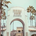 Vista de la icónica entrada de Universal Studios con palmeras y cielo azul