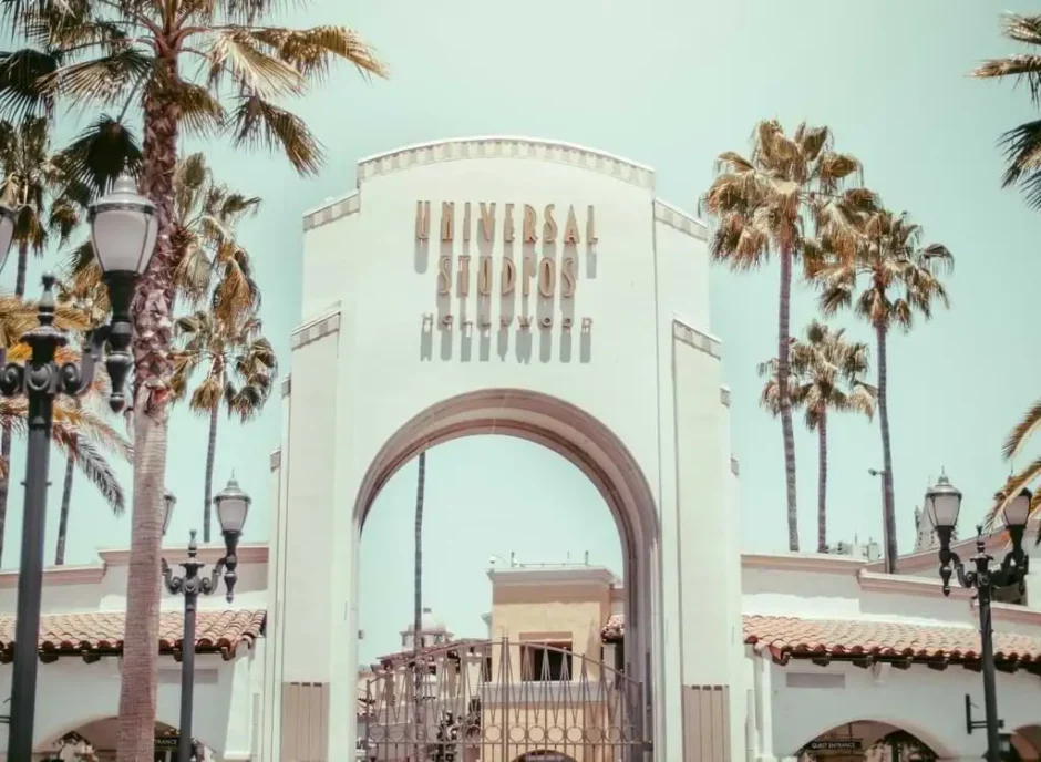 Vista de la icónica entrada de Universal Studios con palmeras y cielo azul