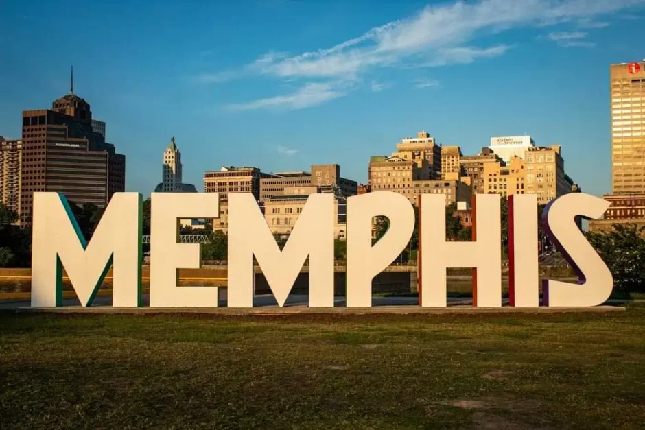 Instalación artística de grandes letras que forman la palabra MEMPHIS en un parque con el horizonte de la ciudad al fondo.