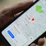 Mano sosteniendo un teléfono inteligente con la aplicación de mapas de Google abierta, mostrando la ubicación de una carnicería en un mapa urbano